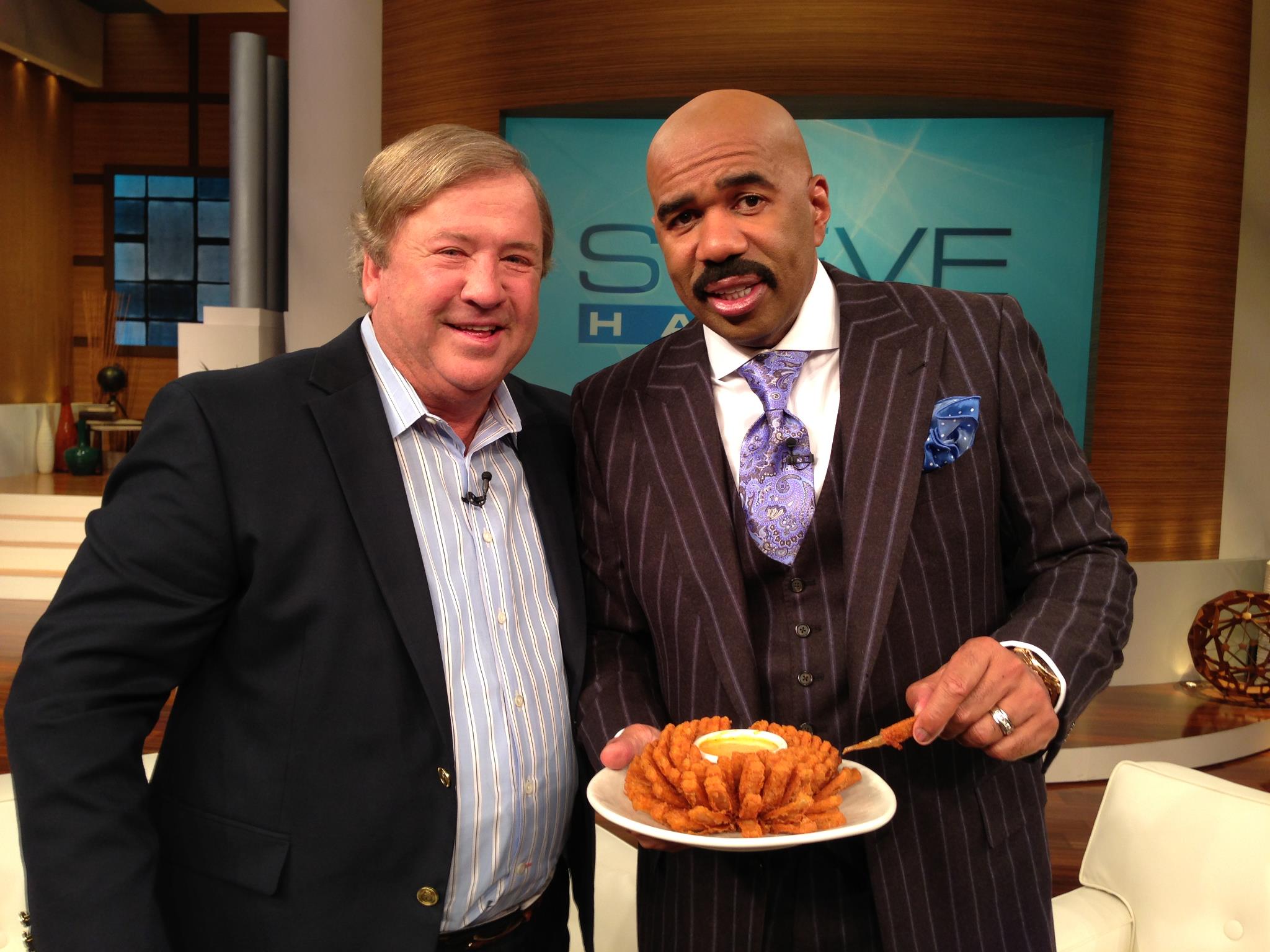 Tim Gannon with Steve Harvey holding Bloomin Onion